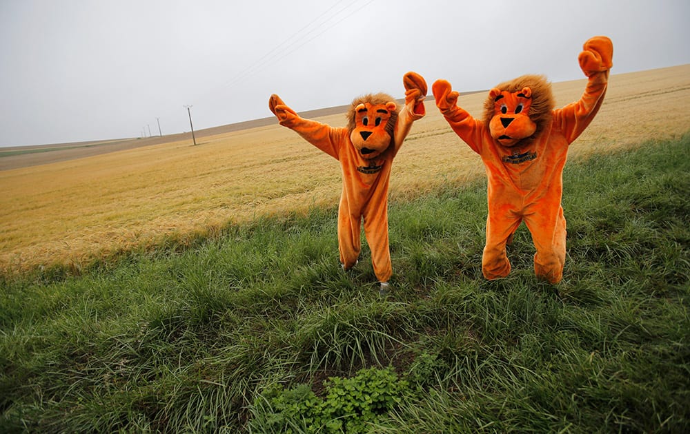 Two cycling fans in disguise wait for the pack to pass during the sixth stage of the Tour de France cycling race over 194 kilometers (120.5 miles) with start in Arras and finish in Reims, France.