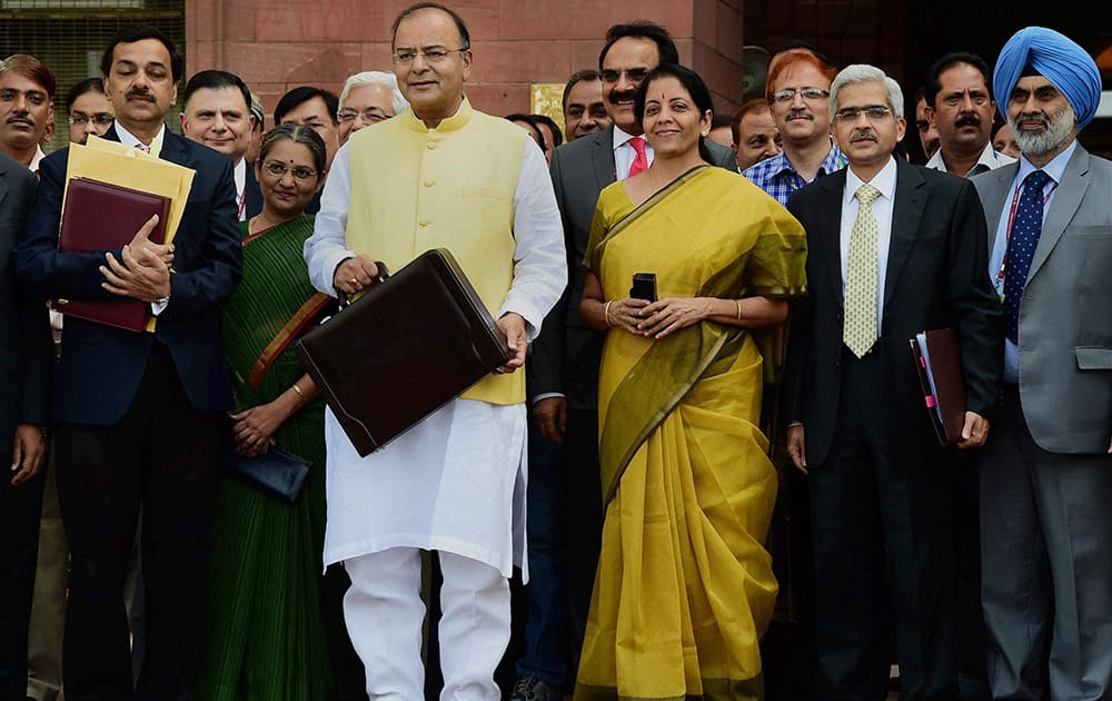 Union Finance Minister Arun Jaitley with MOS for Finance Nirmala Sitharaman and officials outside Finance Ministry before leaving for Parliament to present the annual budget 2014-15, in New Delhi.