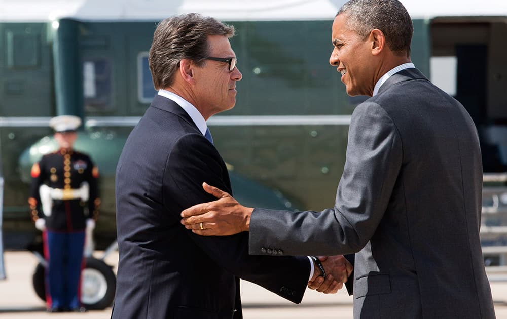 President Barack Obama, right, and Texas Gov. Rick Perry shake hands as Obama arrives in Dallas where they will attend a meeting about the border and immigration together.