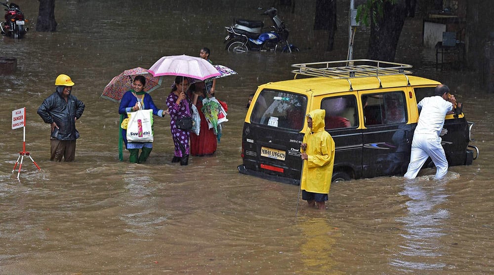 People wade through a waterlogged street after heavy rains in Mumbai.
