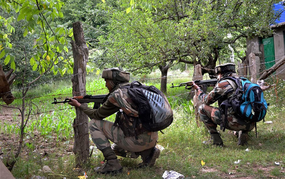 Army personnel takes position during an encounter with militants at Hamlapati village in Handwara.