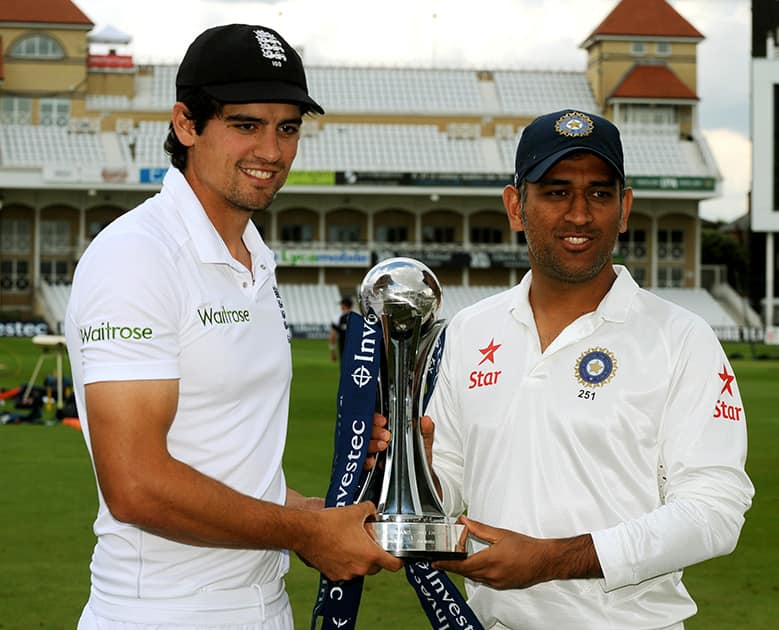 England captain Alastair Cook. left, and India captain M.S. Dhoni pose with the Trophy during a photocall ahead of the first Test Match between England and India at Trent Bridge cricket ground, Nottingham, England.