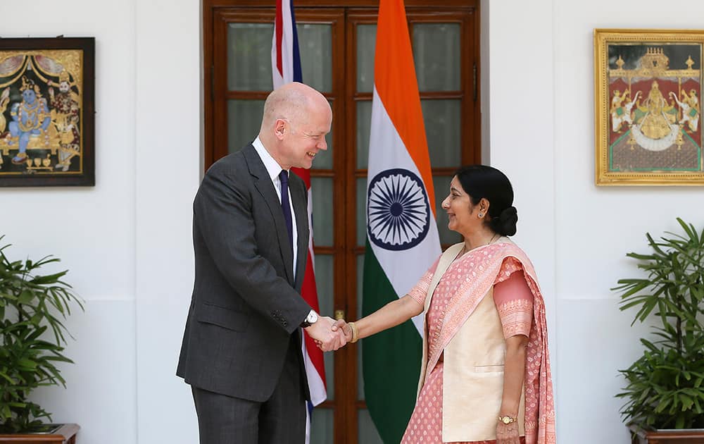 Foreign Minister Sushma Swaraj, right, shakes hand with British Foreign Secretary William Hague, in New Delhi.