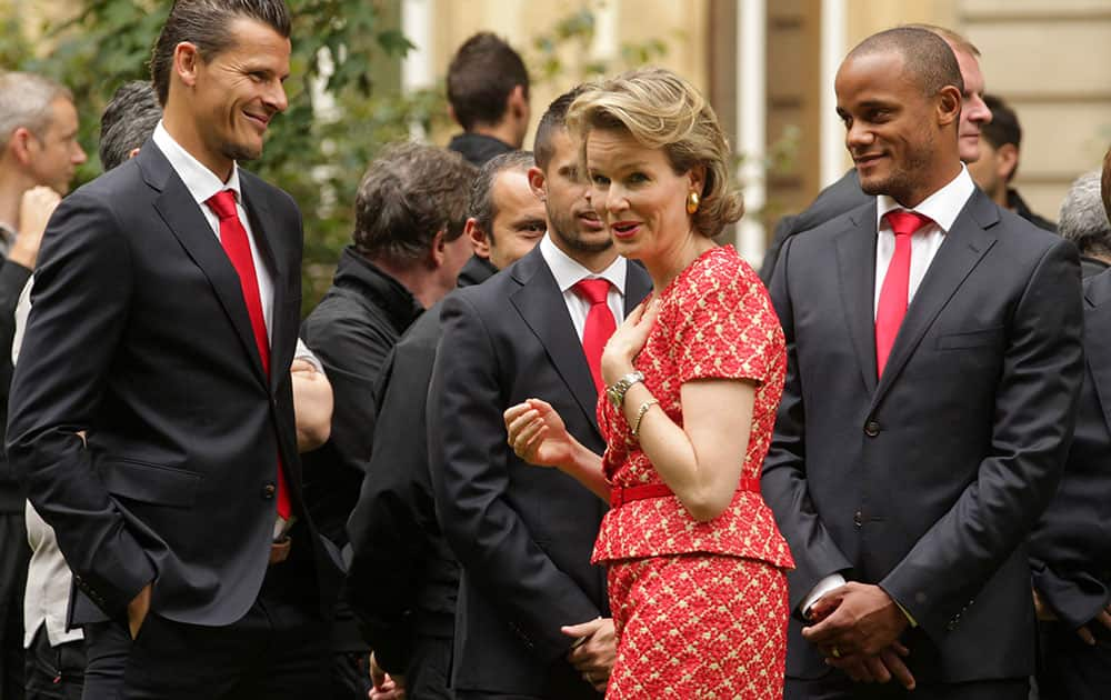 Belgian Queen Mathilde , centre, talks with players of the Belgian national soccer team, Daniel Van Buyten, left, and team captain Vincent Kompany, right, at an event held after the team`s return from Brazil, at the Royal Palace in Brussels.