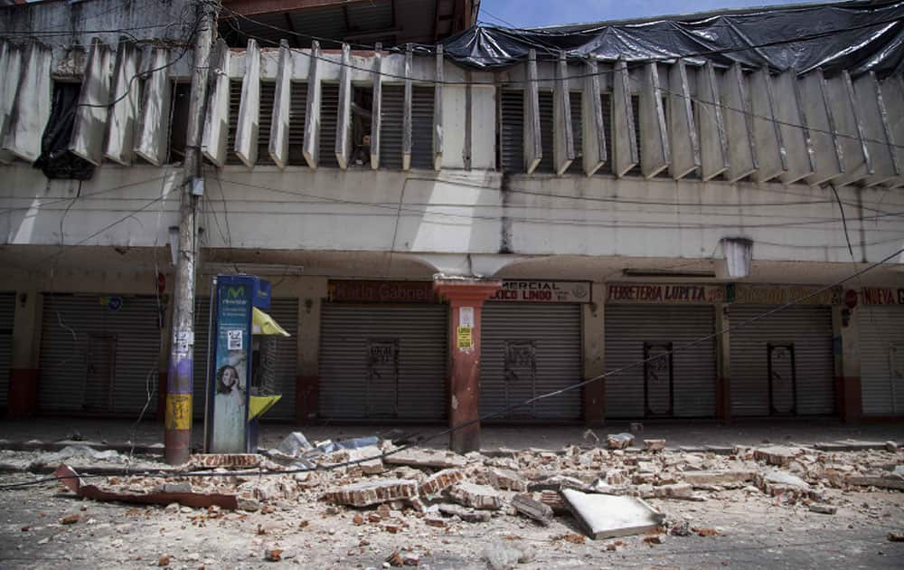 Wreckage and debris from buildings damaged by an earthquake lie on the street of San Pedro, Guatemala, Monday, July 7, 2014. An earthquake measuring 6.9 on the Pacific Coast shook a wide area of southern Mexico and Central America Monday.