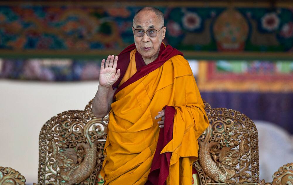 Tibetan spiritual leader the Dalai Lama gestures to devotees before he starts teaching on the fifth day of Kalachakra near Leh.