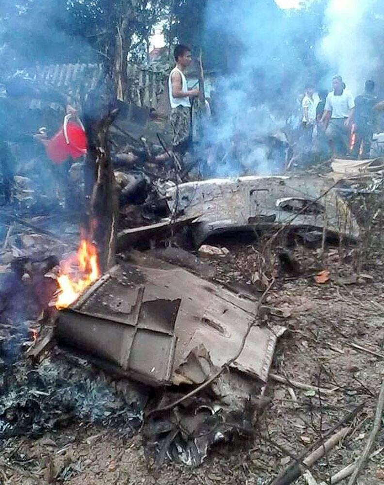 Vietnamese military personnel look at the burning wreckage of a military helicopter in Hanoi, Vietnam. The helicopter was on a parachute training mission when it crashed close to the Vietnamese capital on Monday, killing 16 people on board and wounding five others.