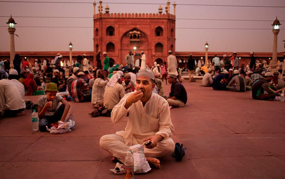 A Muslim eats during Iftar, the sunset meal when Muslims break their fast during the holy month of Ramadan, at the Jama Masjid mosque in New Delhi.