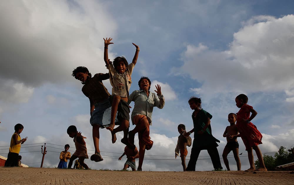 Children play as monsoon clouds hover in the sky, in Allahabad.