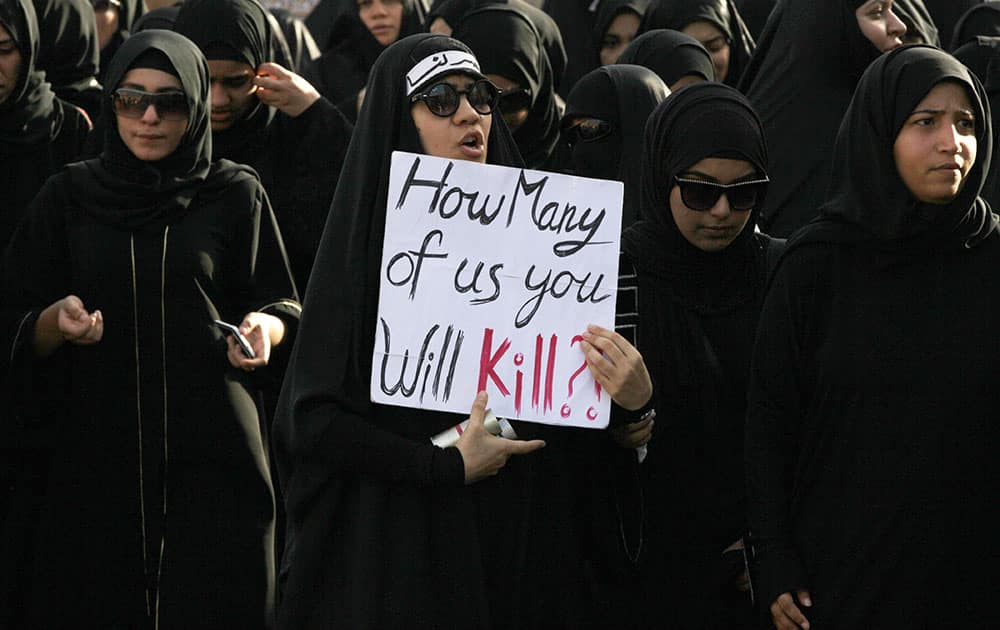 Bahraini mourners, one wearing a headband that reads, `victory is ours,` carry signs and chant anti-government slogans during the funeral for a protester in Sanabis in the suburbs of the capital of Manama, Bahrain.