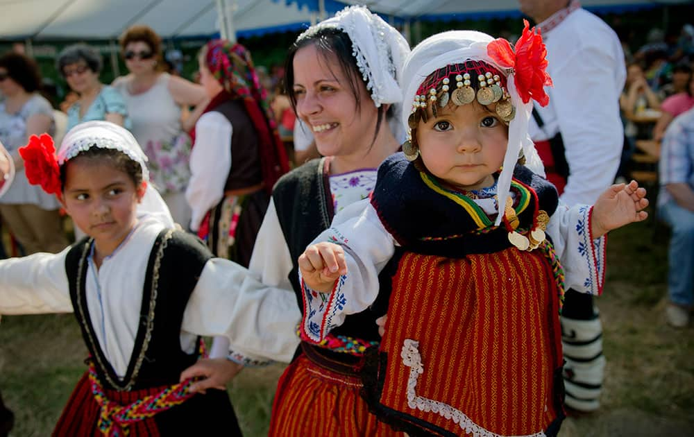 A Bulgarian woman holds 2 year-old Kristina while dancing at a wedding in Pchelina, Bulgaria.