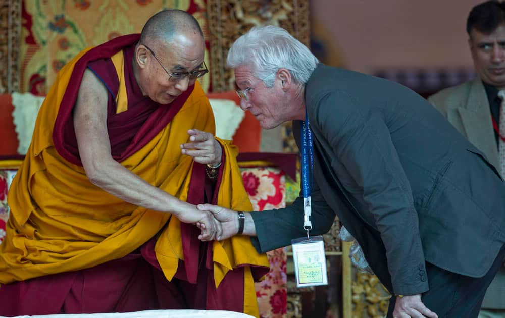 Tibetan spiritual leader the Dalai Lama shakes hand with hollywood actor Richard Gere, right, before teachings on the fourth day of Kalachakra near Leh, India.