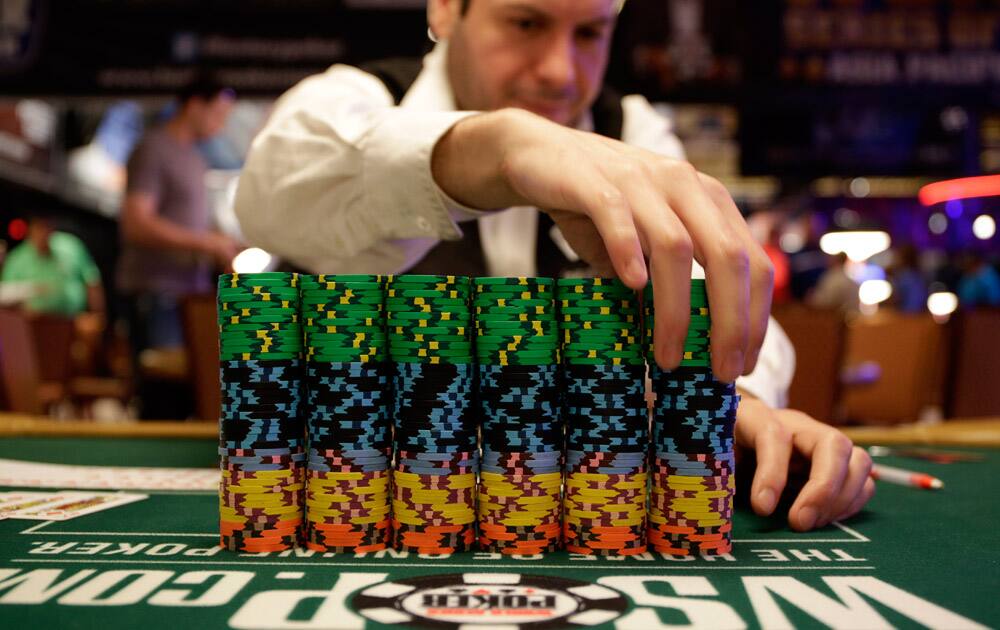 Dealer Omar Abu-Eid adjusts a stack of chips before the first day of the World Series of Poker main event in Las Vegas.