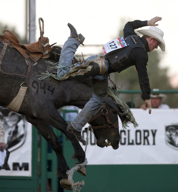 Jacobs Crawley of Stephenville, Texas, comes off the horse in the saddle bronco riding event at Reno Rodeo in Reno.