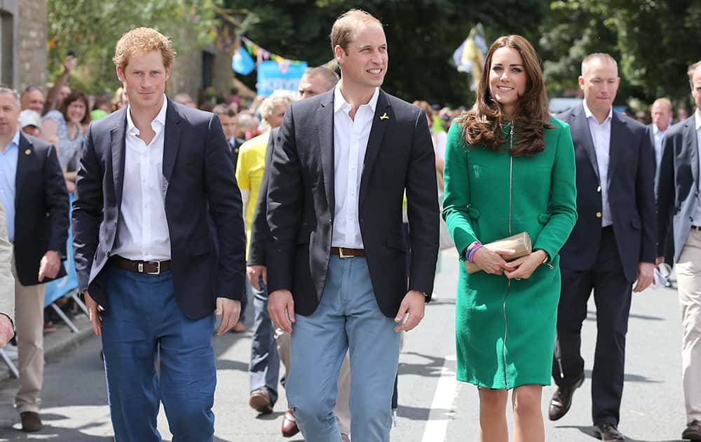 Prince William, Kate Duchess of Cambridge and Prince Harry walk along the street to celebrate the start of the Tour de France in Yorkshire at West Tanfield, England.