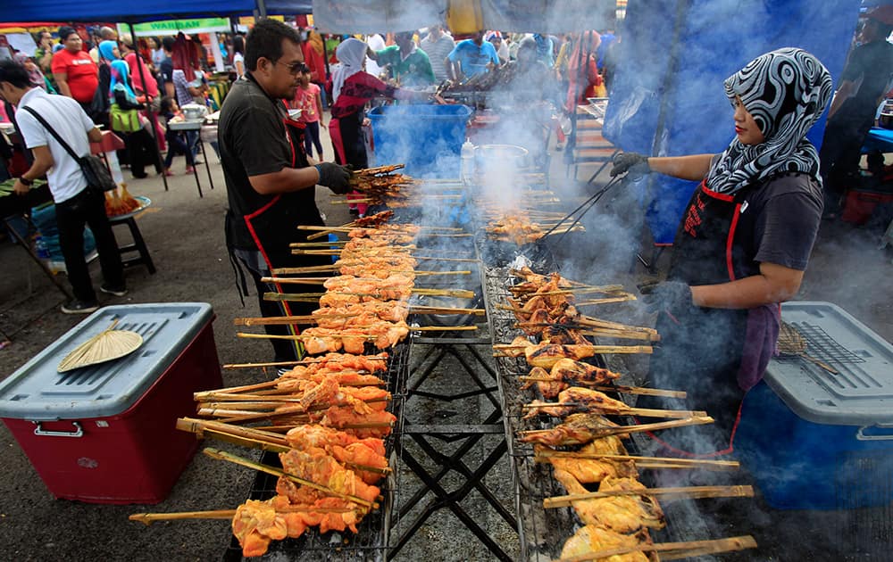 Muslim vendors prepare local dish Ayam Percik for sale at a Ramadan bazaar in Shah Alam, outside Kuala Lumpur, Malaysia.