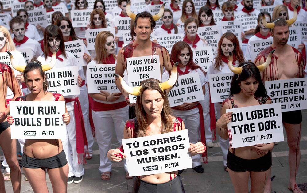 Anti-bullfighting demonstrators protest against the bull runs dressing in the typical white and red colors while displaying banners which read, `You Run. Bulls Die`, on the Ayuntamiento Square in Pamplona northern Spain.