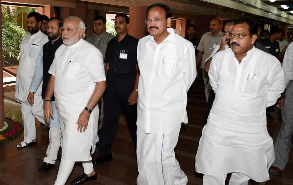 Prime Minister Narendra Modi flanked by Union Minister for Parliamentary Affairs M Venkaiah Naidu and MoS Prakash Javadekar at Parliament House in New Delhi.