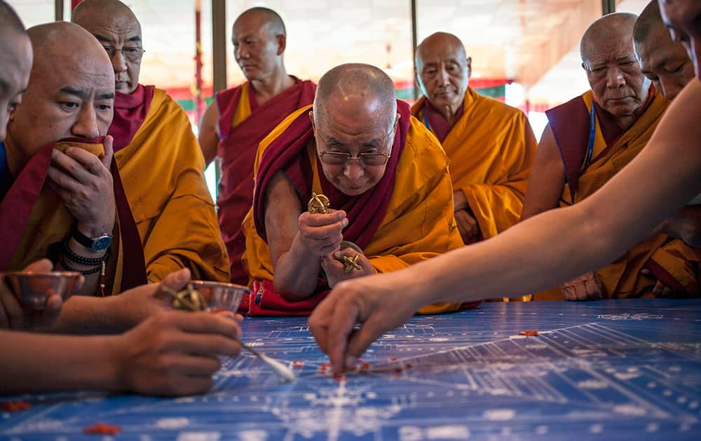 Tibetan spiritual leader the Dalai Lama concentrates during the preparation of a Sand Mandala, a spiritual and ritual symbol depicting the Buddhist universe, during third day of Kalachakra near Leh.