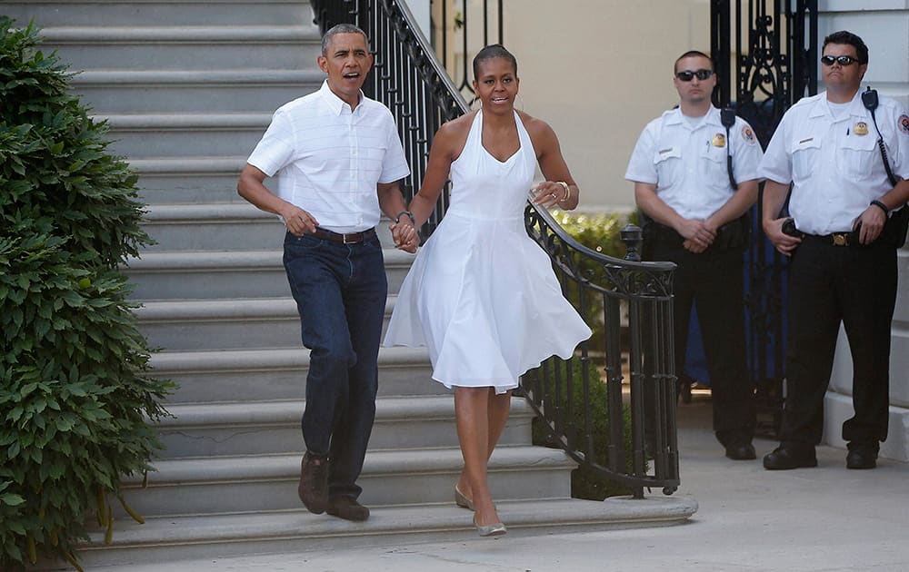 President Barack Obama and first lady Michelle Obama walk from the South Portico to greet military families as they host an Independence Day celebration on the South Lawn at the White House in Washington.