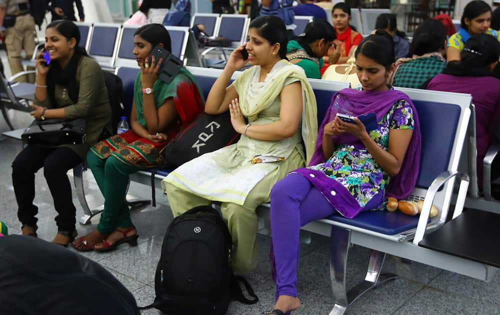 Indian nurses who were trapped in territory captured by Islamic militants wait for the plane to begin their journey home at Irbil International Airport, Iraq.