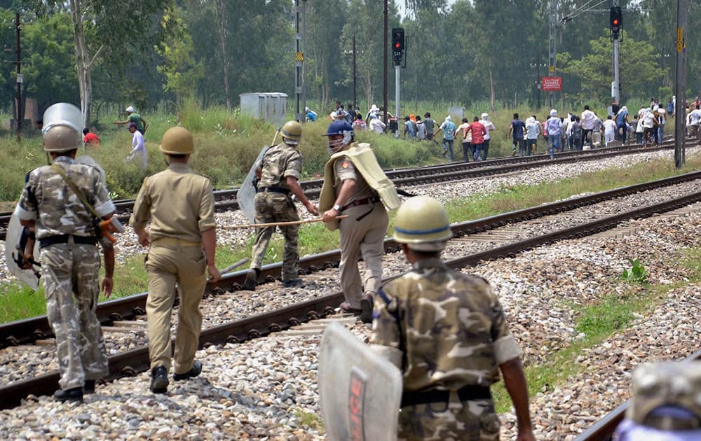 Police men in action against BJP Mahapanchayat supporters during a clash at Kanth Railway Station in Moradabad.