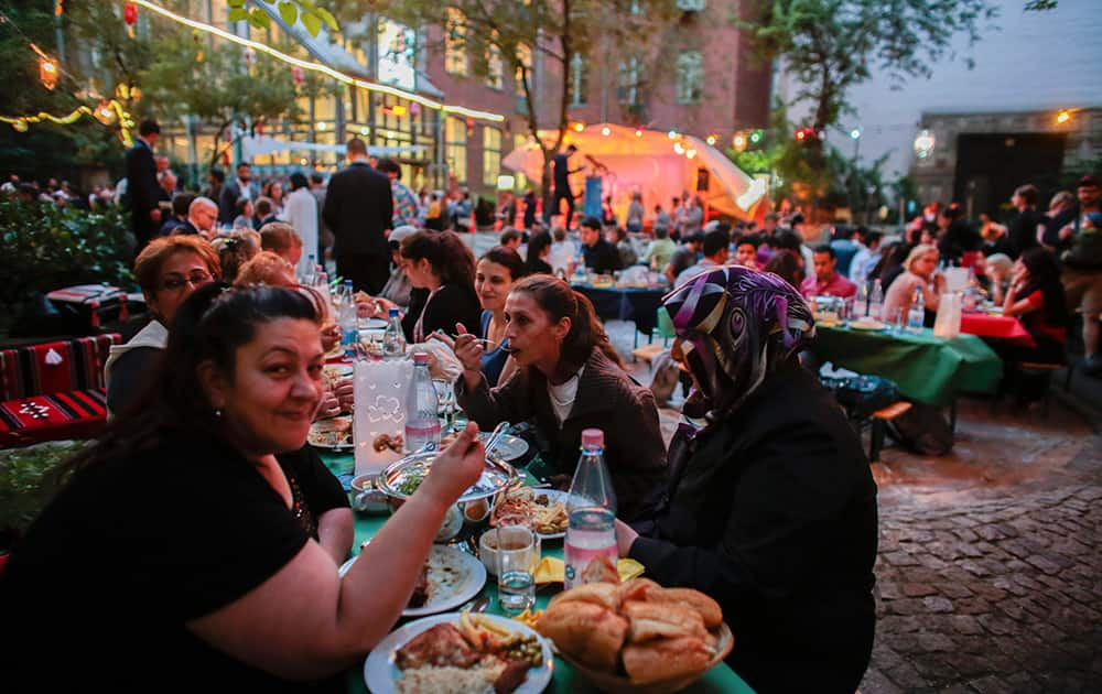 People attend a public Iftar, the evening meal in which Muslims break their fast at the time of sunset during Muslim holy fasting month of Ramadan, in Berlin.