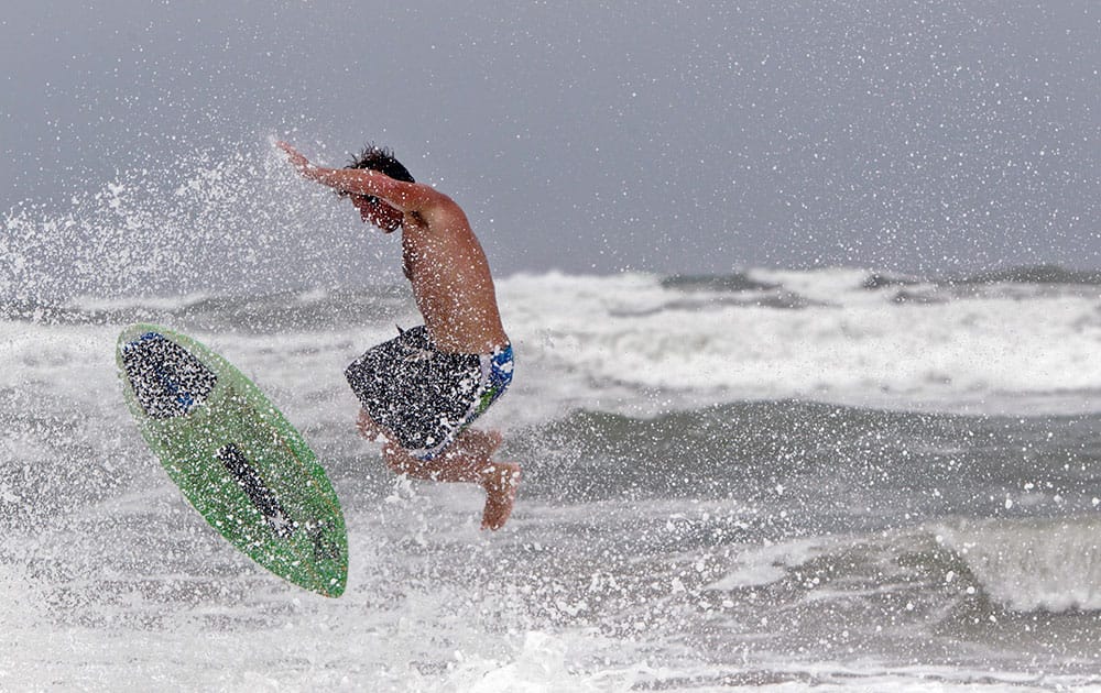 Austin Parker from Newport, N.C., flies up in the air as he rides his skim board into the rough surf generated from the coming of Hurricane Arthur at Atlantic Beach, N.C.