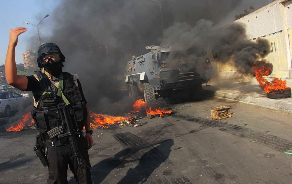 An Egyptian security forces member directs others during clashes against supporters of ousted President Mohammed Morsi in Cairo`s Suez Bridge district, Egypt.