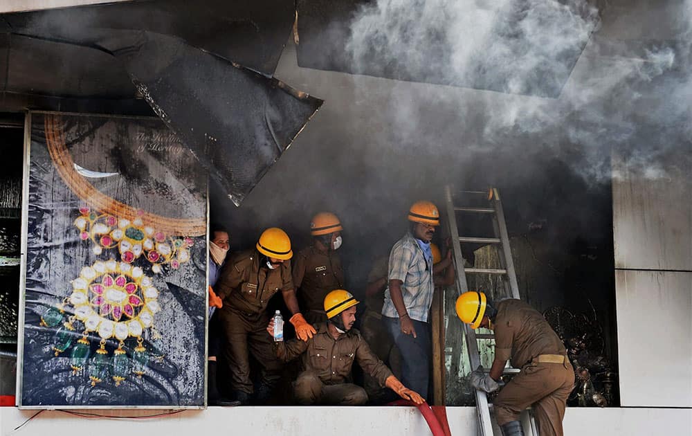 Firefighters trying to douse the fire at a jewellery showroom at M G road in Bengaluru.