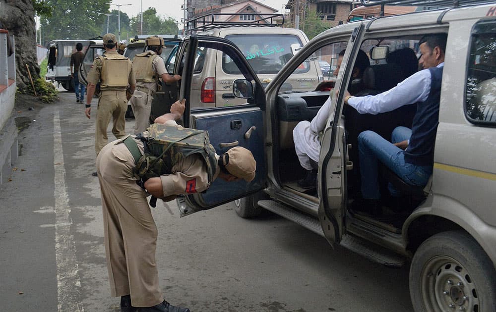 Policemen check vehicles in Srinagar.