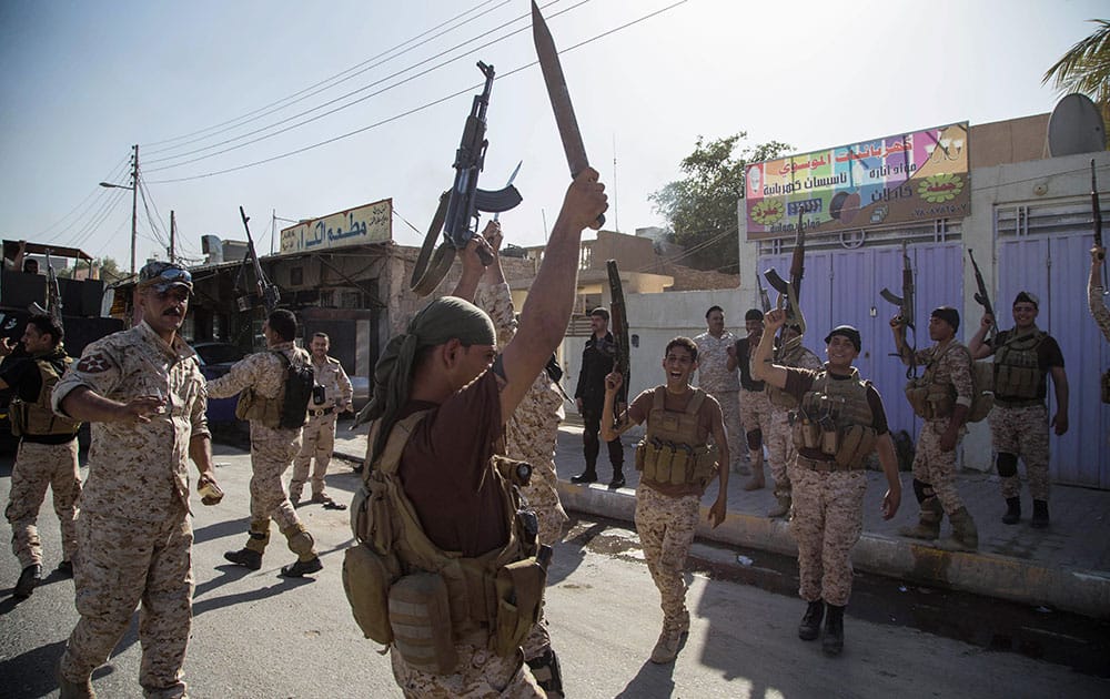 Iraqi security forces celebrate after clashes with followers of Shiite cleric Mahmoud al-Sarkhi, in front of his home in the Shiite holy city of Karbala.