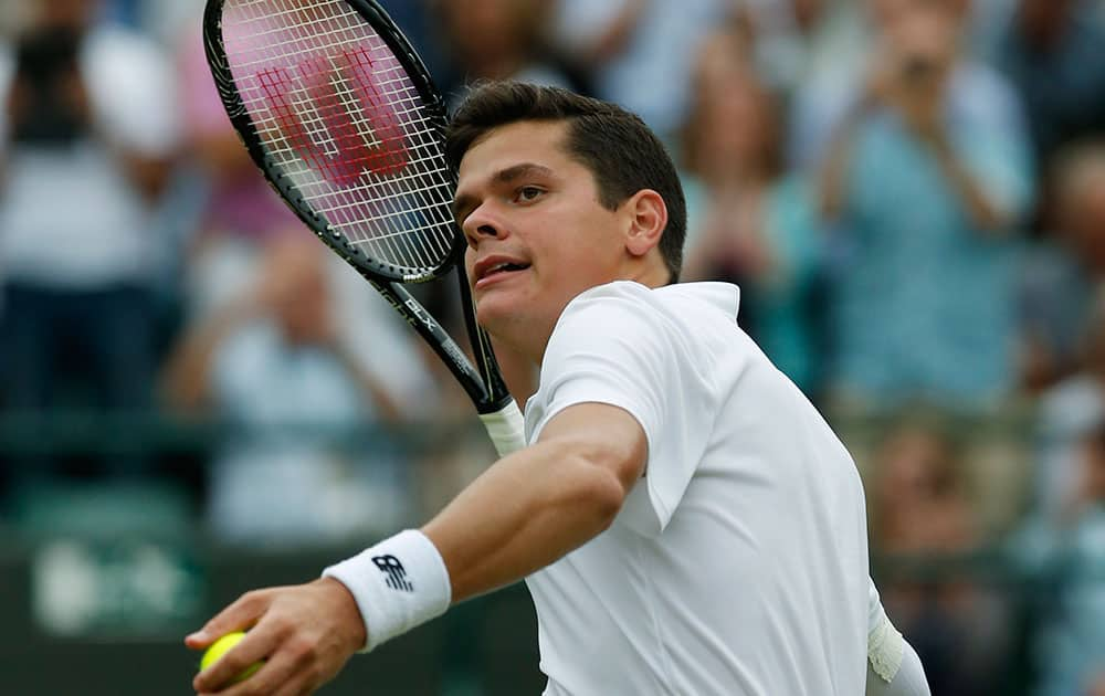 Milos Raonic of Canada tosses the ball to the crowd after defeating Nick Kyrgios of Australia in their men`s singles quarterfinal match at the All England Lawn Tennis Championships in Wimbledon.