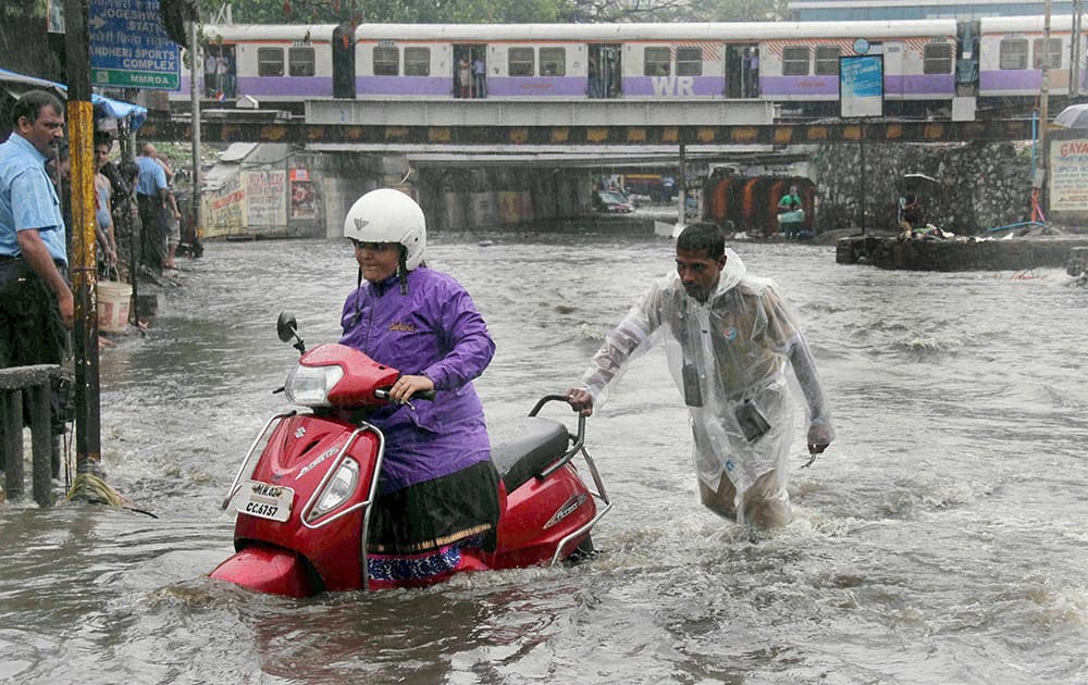 A vehicle moves through a water logged street as the city experienced heavy rainfall in Mumbai.