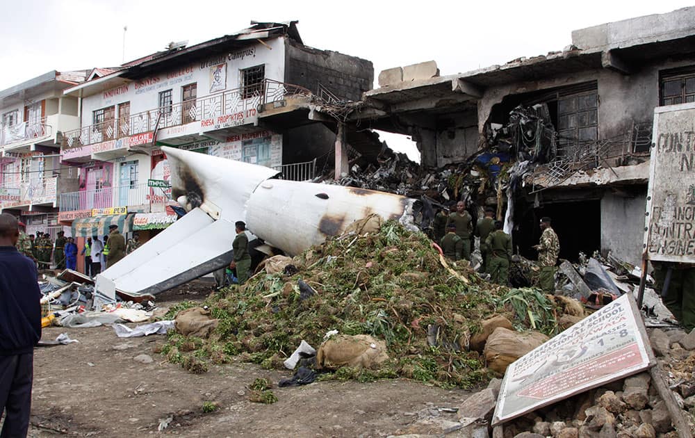 A pile of mild stimulant drug Khat llies beside the wreckage of a Fokker 50 cargo plane after it crashed into a building on take-off at Kenyatta International Airport, in Nairobi, Kenya.