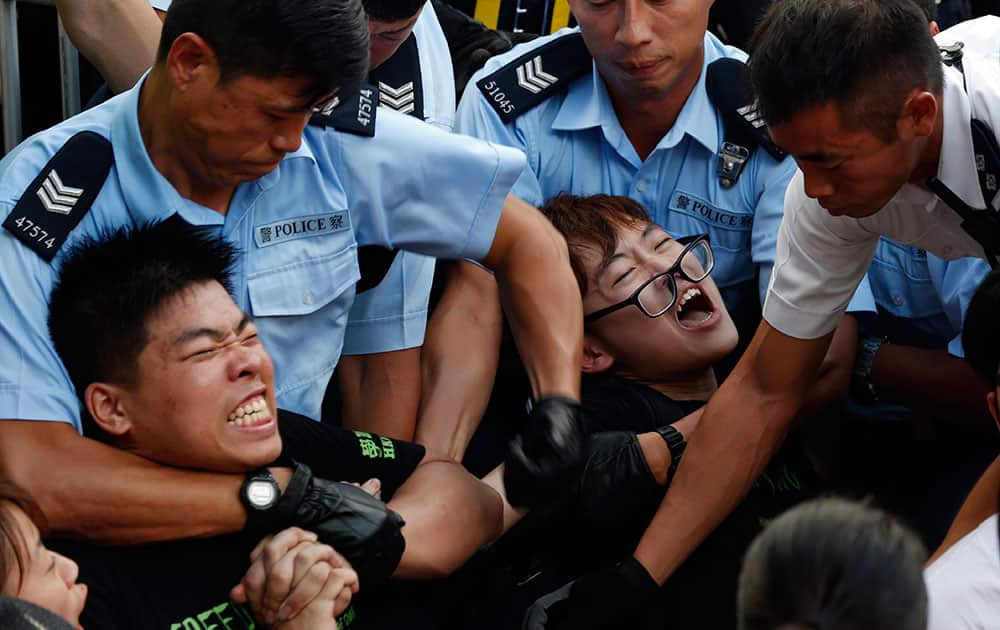 Protesters are taken away by police officers after hundreds of protesters staged a peaceful sit-ins overnight on a street in the financial district in Hong Kong.