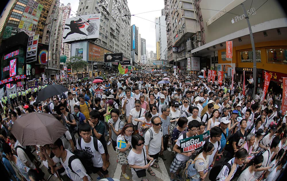 People fill in a street during a march at an annual protest in downtown Hong Kong. ens of thousands of Hong Kong residents marched through the streets of the former British colony to push for greater democracy in a rally fueled by anger over Beijing`s recent warning that it holds the ultimate authority over the southern Chinese financial center. 