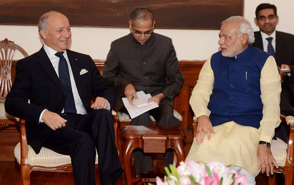 French Foreign Minister Laurent Fabius, left, talks with Indian Prime Minister Narendra Modi during their meeting at his residence in New Delhi. Fabius is in India for a two-day official visit.