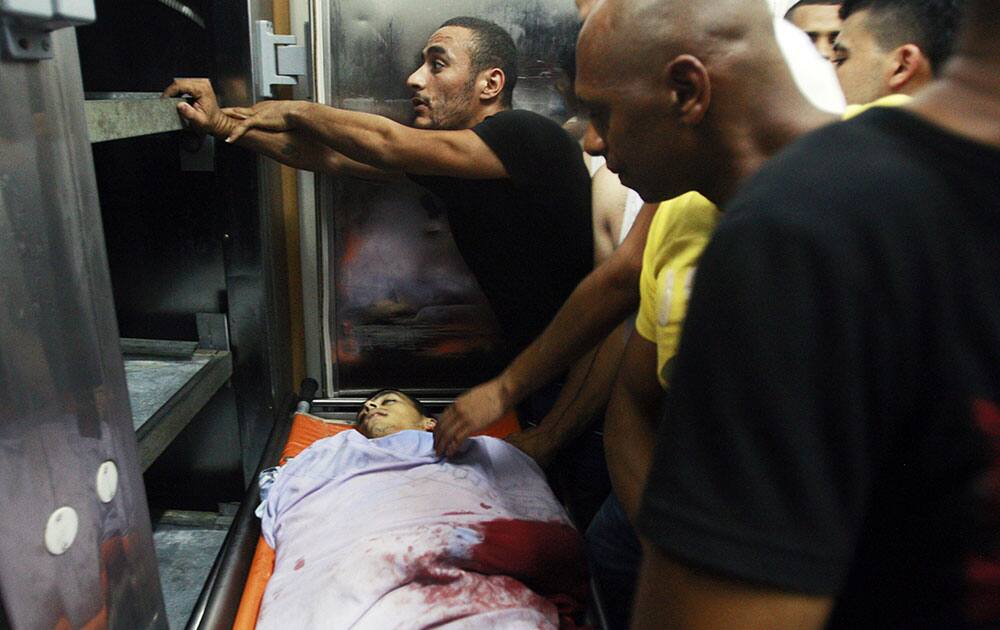 Palestinians gather around the body of Yosuf abu Zaghah, 20, who was killed by Israeli troops in the West Bank refugee camp of Jenin.