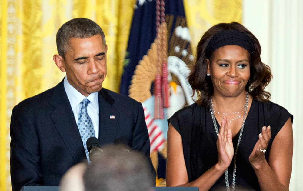 President Barack Obama, left, with first lady Michelle Obama, speaks during a reception to observe LGBT Pride Month in the East Room of the White House in Washington.