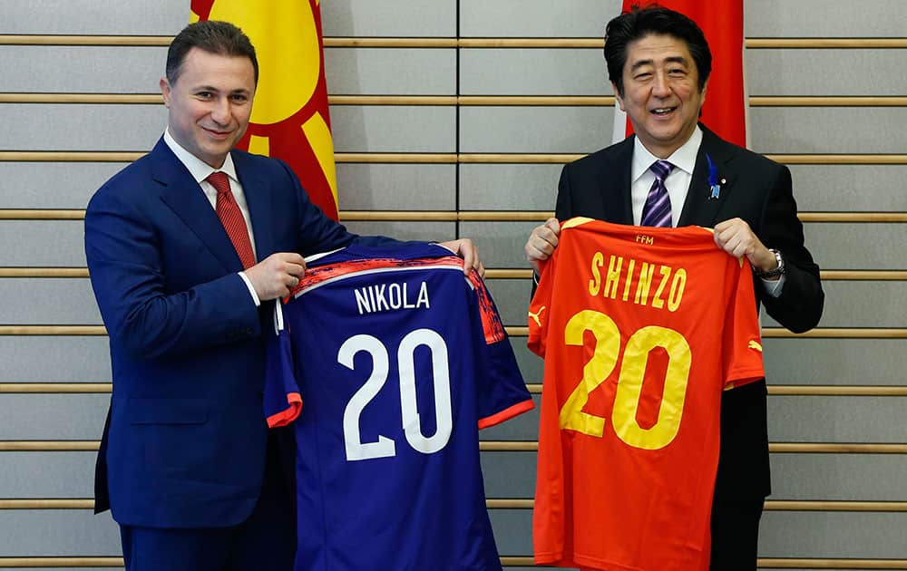 Macedonia`s Prime Minister Nikoa Gruevski, left, and Japan`s Prime Minister Shinzo Abe show uniforms of their country`s national soccer teams after exchanging them before their meeting at Abe`s official residence in Tokyo.