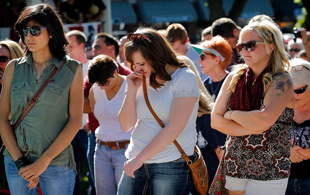 People gather to honor the 19 Granite Mountain Hotshots on the first anniversary of their deaths, during a ceremony outside the Yavapai County courthouse in Prescott, Ariz.