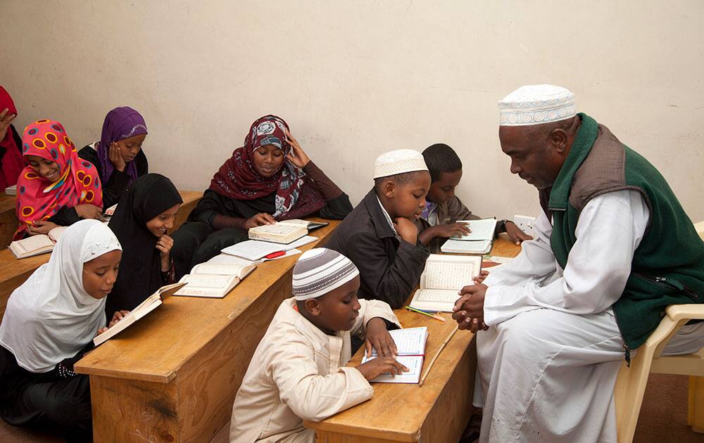 A teacher listens as children recite the Quran at the start of Muslim holy month of Ramadan at a madrassa, or Islamic school in Nairobi, Kenya.