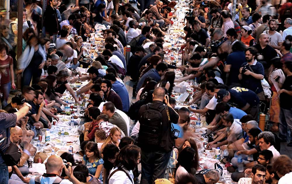 Hundreds of people sit, awaiting for Iftar, the evening meal in which Muslims break their fast at the time of sunset, during the Islamic month of Ramadan in Istanbul, Turkey.