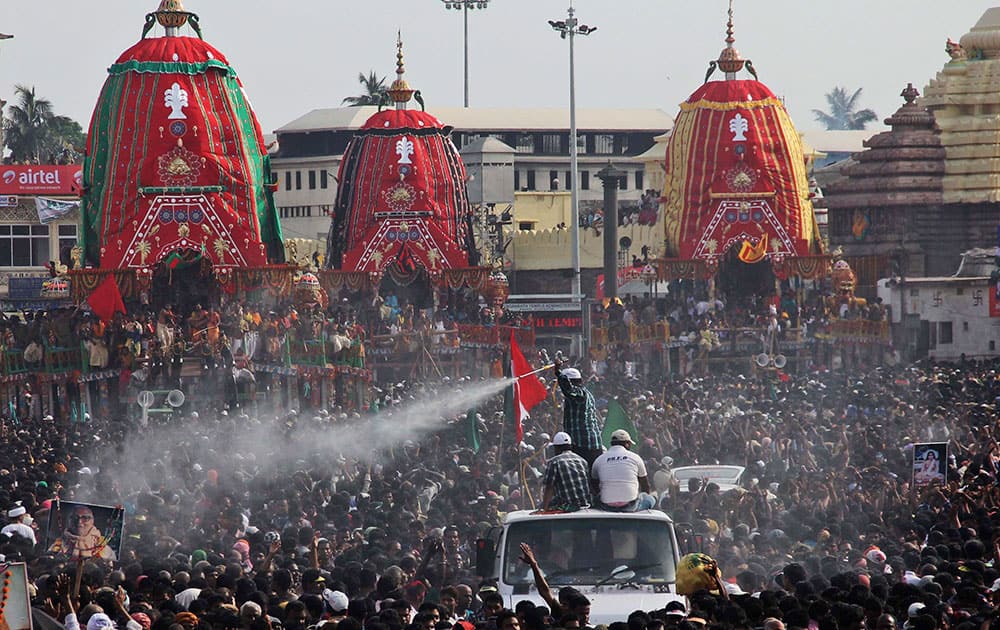 Volunteers spray water on devotees to cool them during the annual Hindu festival ‘Rath Yatra’ or chariot procession in Puri, Orissa state.