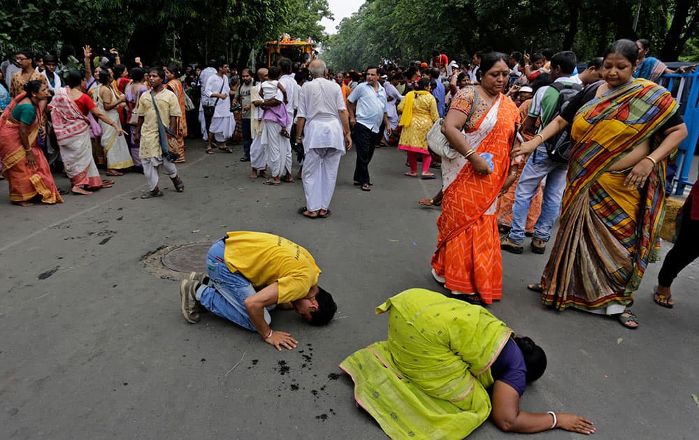 Devotees prostrate on a road as a chariot with idols of Hindu deities pass during the annual Hindu festival ‘Rath Yatra’ or chariot procession in Kolkata, India.