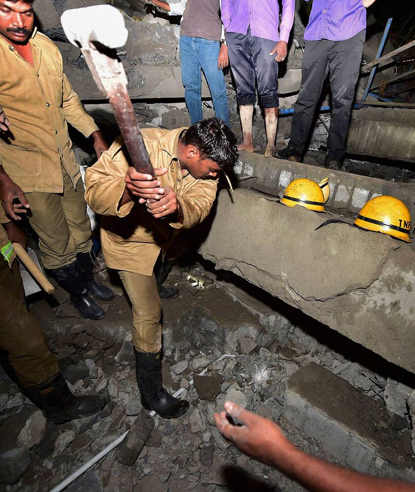 Indian rescue workers search for survivors in the rubble of a collapsed building on the outskirts of Chennai, India.