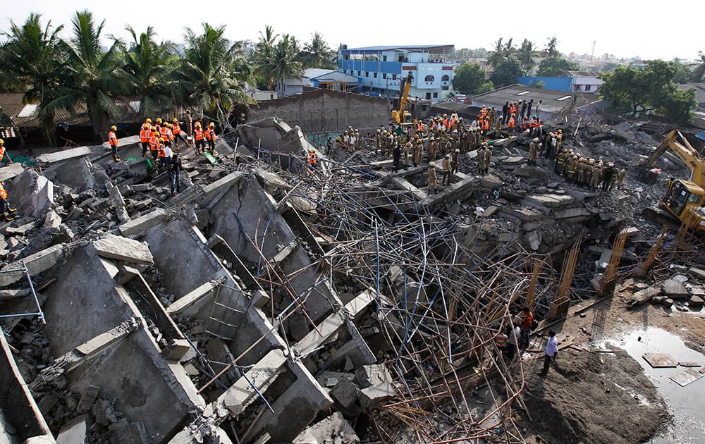 Rescuers search for workers believed buried in the rubble of a building that collapsed on the outskirts of Chennai, India.