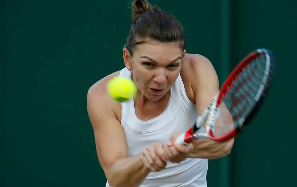 Simona Halep of Romania plays a return to Belinda Bencic of Switzerland during their women`s singles match at the All England Lawn Tennis Championships in Wimbledon, London.