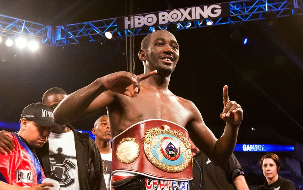 Terence Crawford wears the WBO lightweight title belt after defeating Yuriorkis Gamboa in the ninth round of the boxing bout in Omaha, Neb.